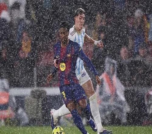 暴雨傾瀉進諾坎普球場，記者紛紛在媒體席上撐起雨傘工作